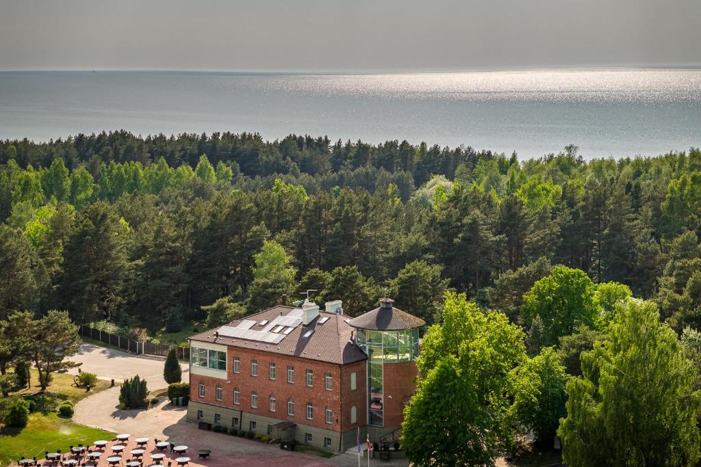 - une vue aérienne sur un grand bâtiment en briques avec des arbres dans l'établissement Roze Village Jūrnieka Ligzda, à Pērkone