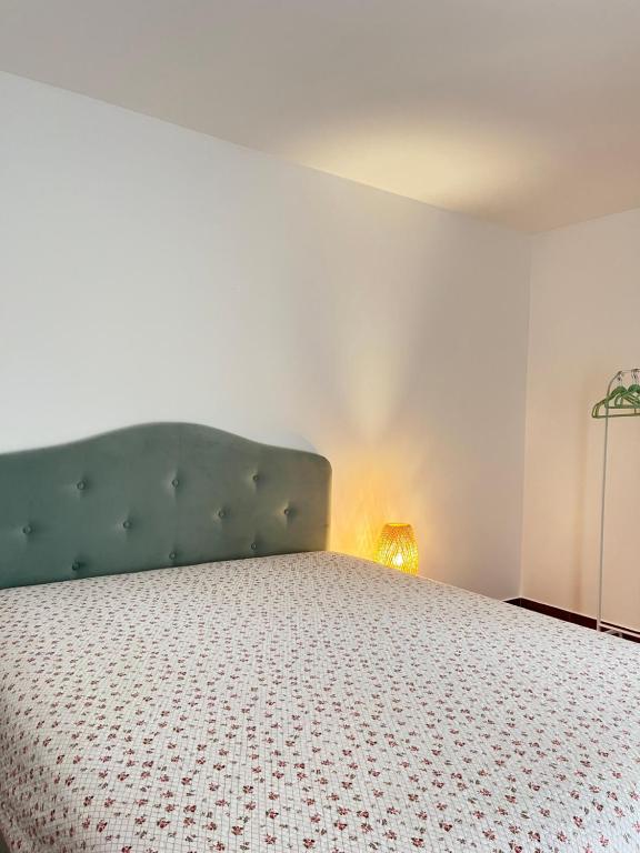 a bedroom with a bed with a green headboard and a lamp at Surčin Apartment in Ledine