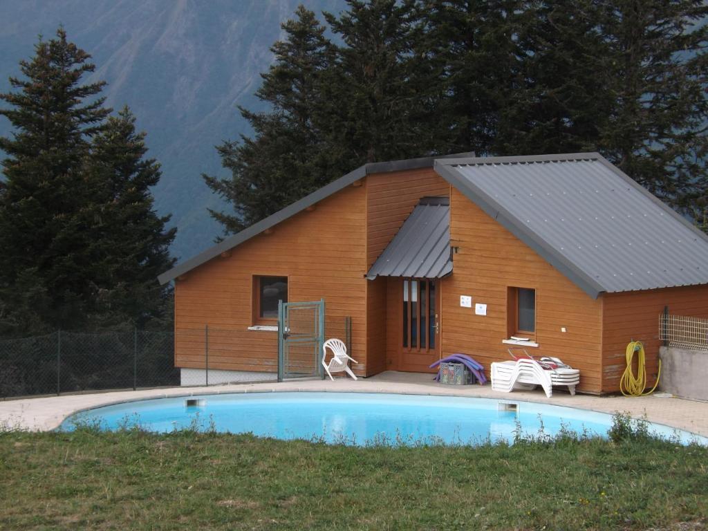 a log cabin with a pool in front of it at Guzet Neige 1400 in Ustou