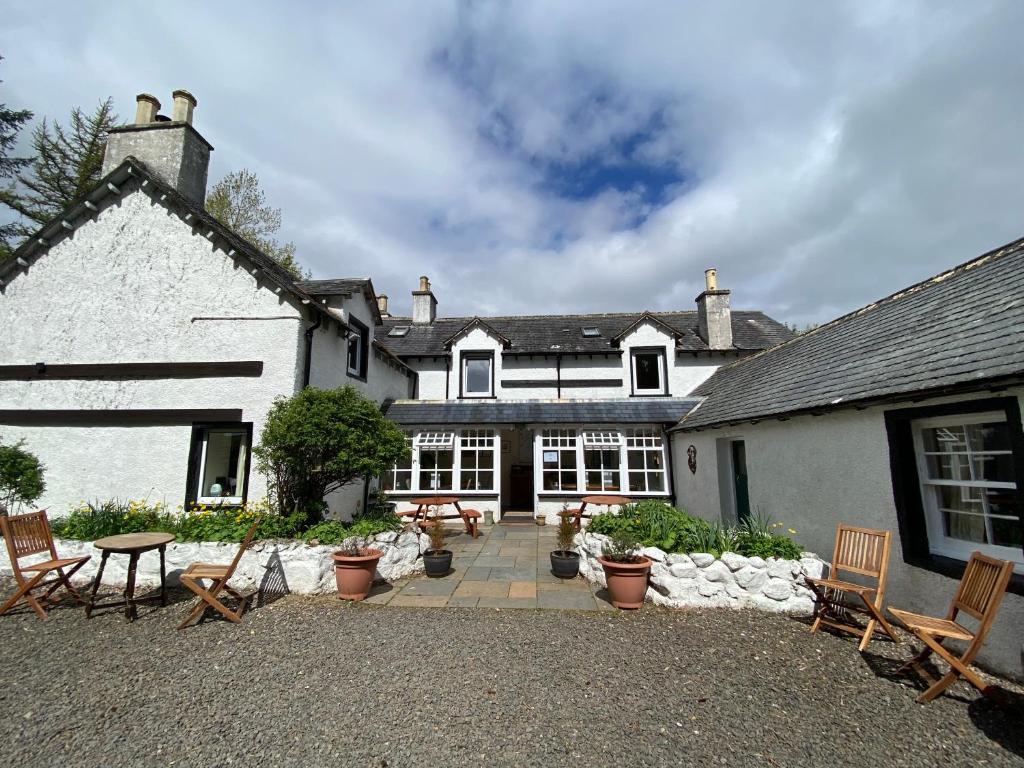 a house with chairs and a patio in front of it at Forsinard Lodge in Forsinard