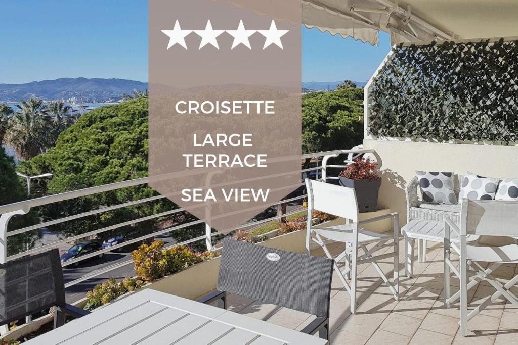 坎城的住宿－SERRENDY Sea View Cannes Croisette，阳台配有椅子,设有阅读大型海景露台的标志。