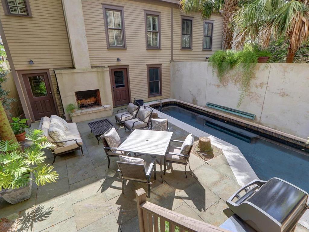 un patio con mesa y sillas junto a una piscina en Southern Elegance Estate, en Savannah