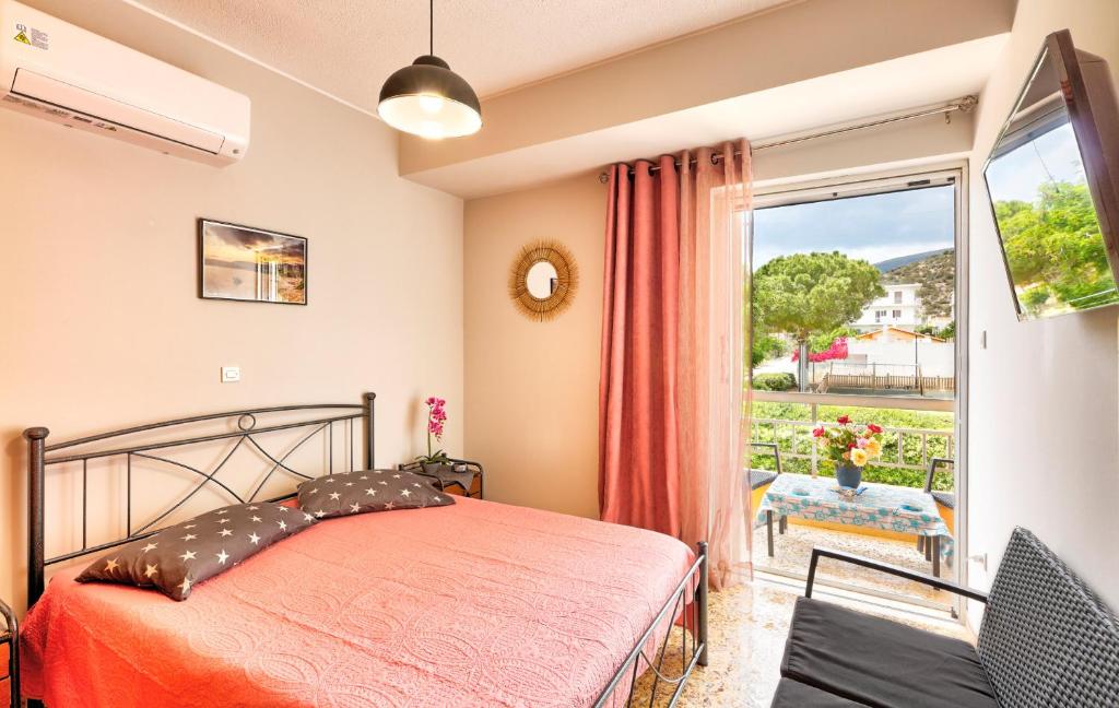 a bedroom with a bed and a sliding glass door at Arilena Studios in Paralia Saranti