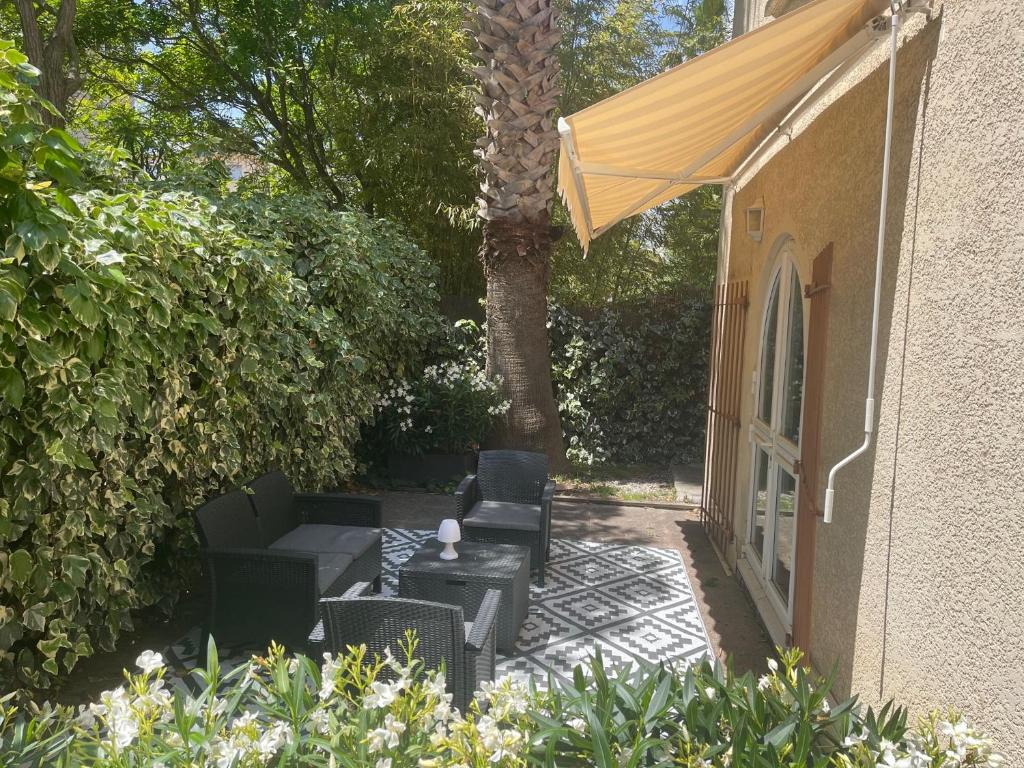 a patio with two chairs and a table and an umbrella at Hôtel Ulysse Montpellier Centre in Montpellier