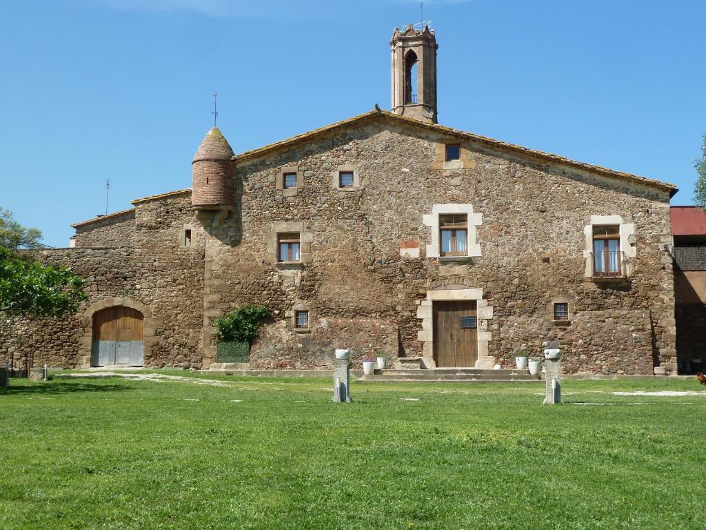 ein altes Steingebäude mit einem Turm darüber in der Unterkunft Mas Solés in Parlavà