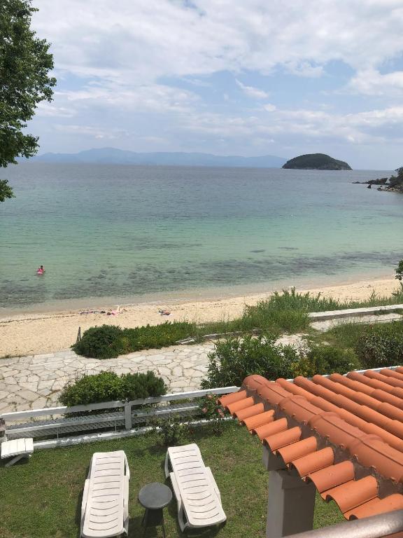 a view of a beach with two lounge chairs at Palio beach house in Paleo Tsifliki