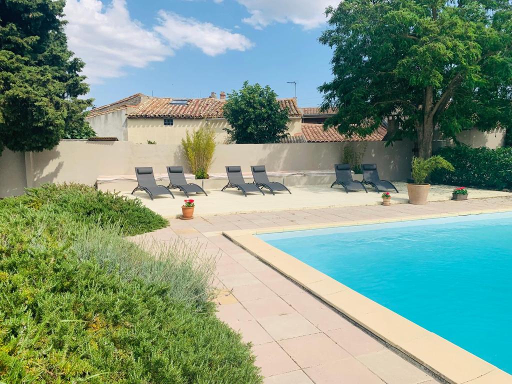 una piscina con tumbonas junto a una casa en Maison de Margot, en Peyriac-Minervois