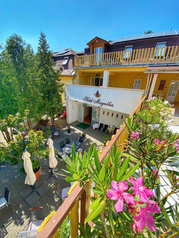 a balcony of a hotel with plants and flowers at Hotel Magnólia in Balatonszepezd