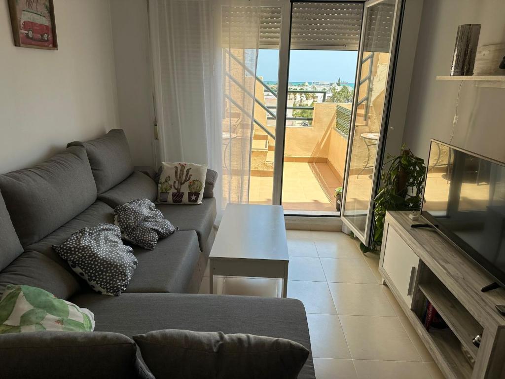 d'un salon avec un canapé et une vue sur un balcon. dans l'établissement Ático con piscina privada vistas al mar., à Vera