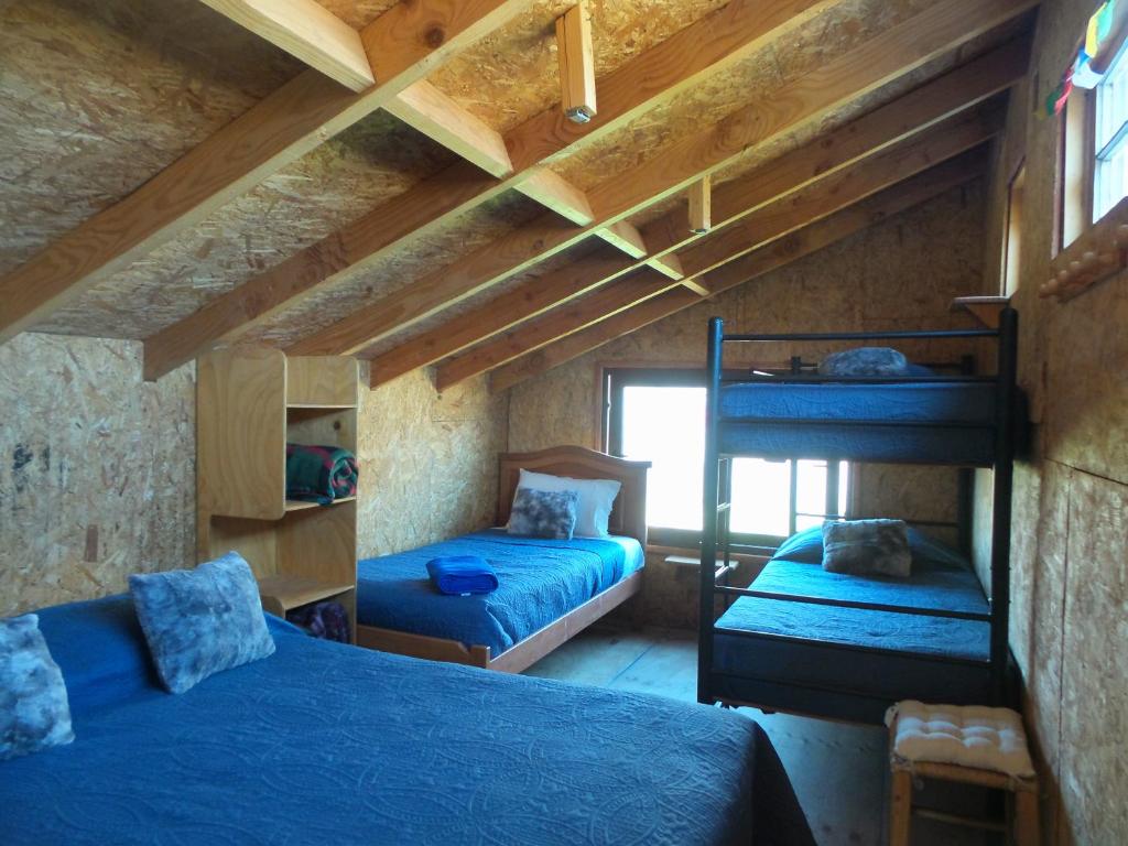 a bedroom with two bunk beds and a window at Tierras Bayas Mountain Refuge in Los Cipreses