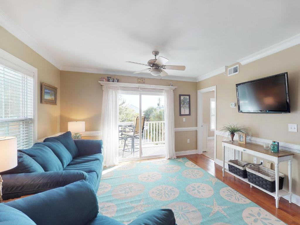 a living room with a blue couch and a flat screen tv at Silver Shores Unit 8 in Tybee Island