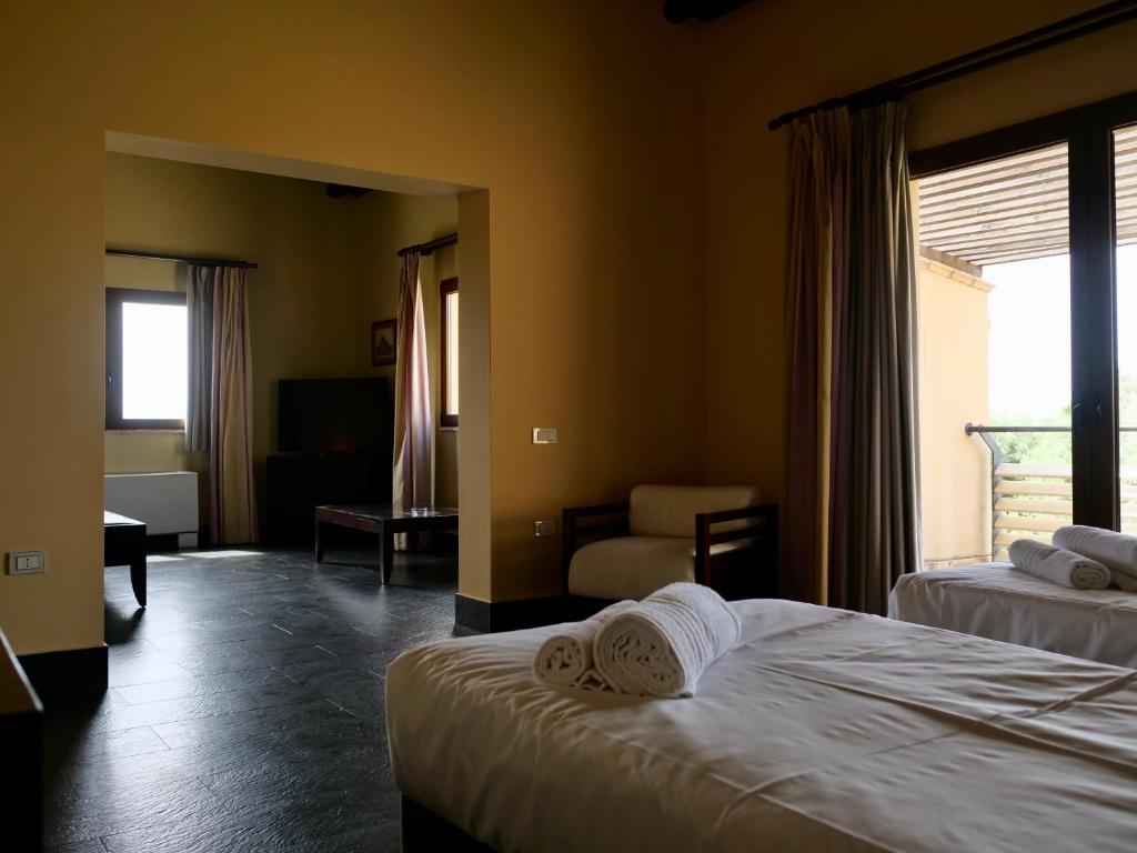 A bed or beds in a room at Falconara Greenblu Resort