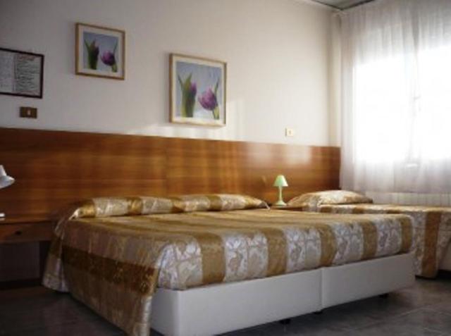 1 dormitorio con 1 cama grande y cabecero de madera en Hotel Sport, en Portogruaro