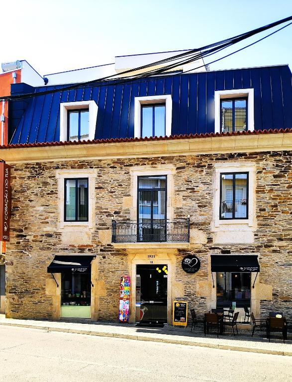 a large brick building with a blue roof at Coração do Tua Hotel in Mirandela
