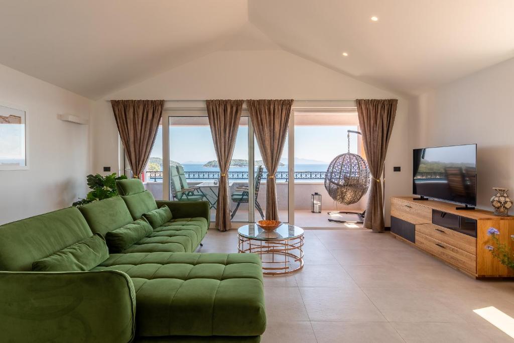 a living room with a green couch and a television at Apartment Cerin Prizba in Blato