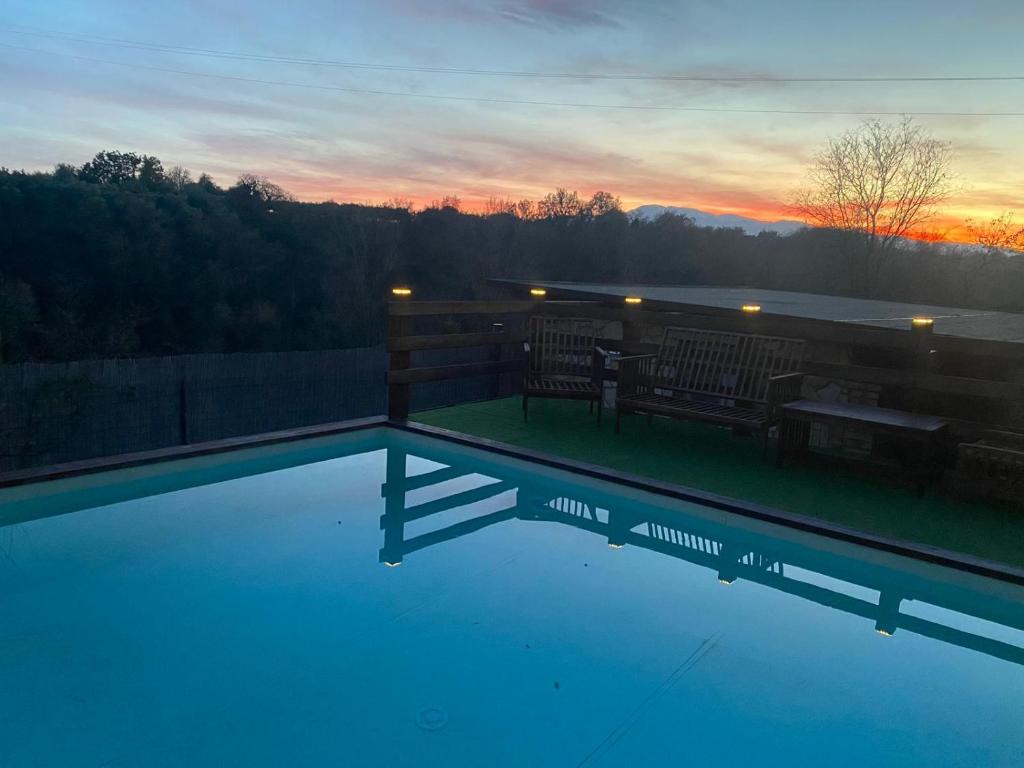 a swimming pool with a sunset in the background at Villa Paola in Villa San Leonardo