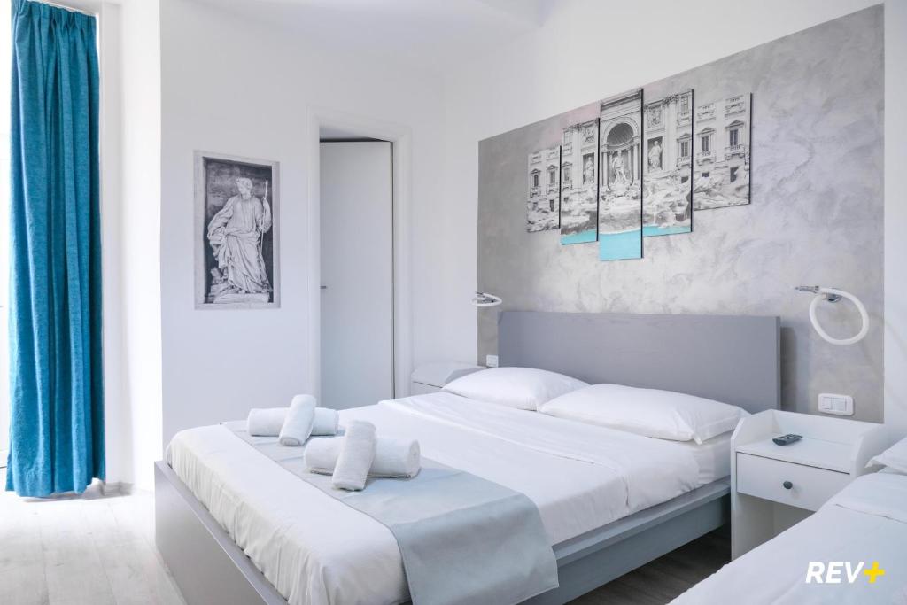 ローマにあるヴィアレ ジュリオ チェザーレ ゲストハウスの白いベッドルーム(ベッド2台付)が備わります。