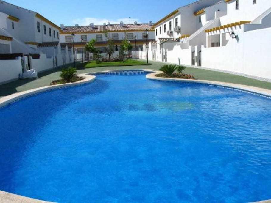 a large blue swimming pool in front of a building at Beach Holiday home with wifi and air con in Torre de la Horadada