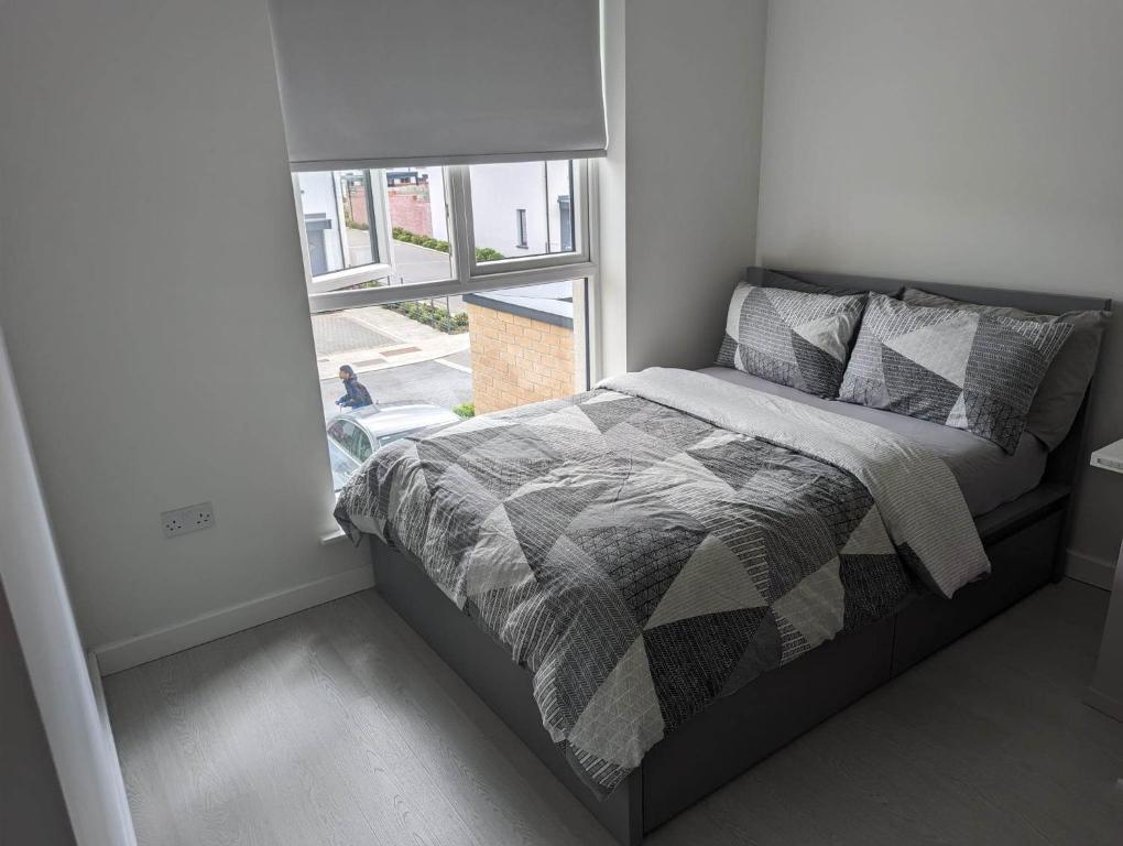 Cama en habitación pequeña con ventana en New House, Private Rooms in a Peaceful Neighborhood en Dublín