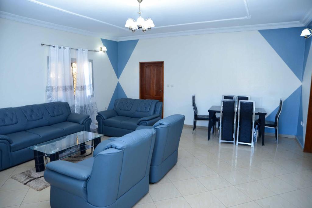 una sala de estar con sofás azules y una mesa. en Appart meuble Jouvence chez Chantal & Francis, en Yaoundé