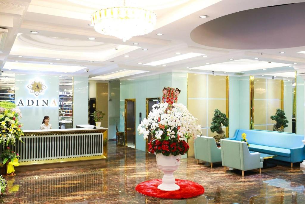 un vestíbulo con un jarrón de flores en el medio en Adina hotel Đa Nang Beach, en Da Nang