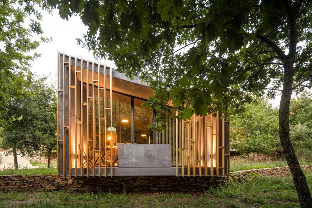 Casa moderna con paredes de cristal y un árbol en Syntony Hotels - Paradinha Village, en Arouca