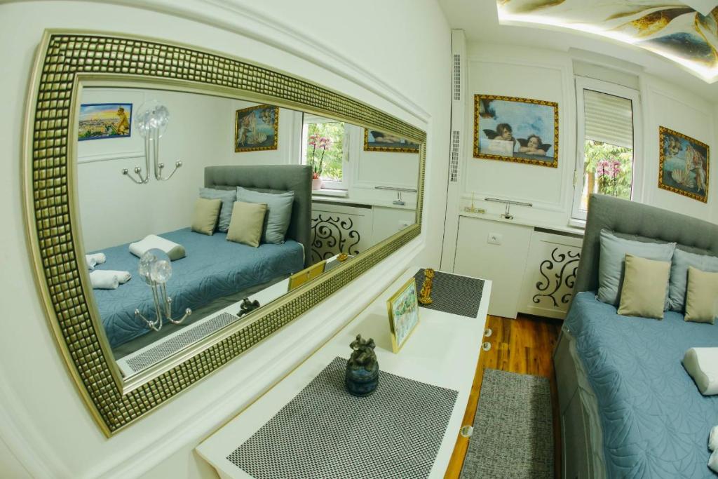 ein Wohnzimmer mit einem Spiegel und einem Sofa in der Unterkunft Pahuljica in Čačak