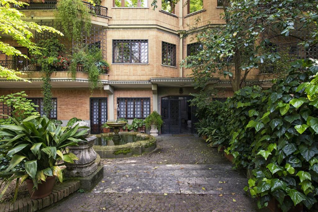 un edificio con un patio con plantas y una fuente en Vatican House Apartment, en Roma