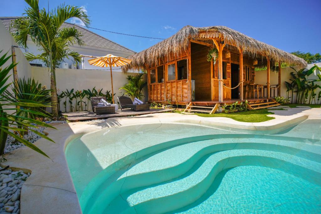 a house with a resort with a swimming pool at Villa Motu Bingin in Uluwatu