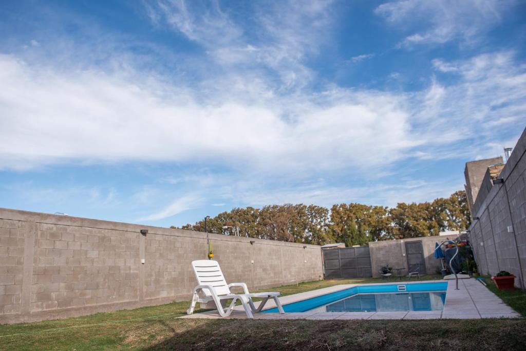 einen Garten mit einem Stuhl und einem Pool in der Unterkunft Alojamiento Turístico Pelucho Sillero in Junín