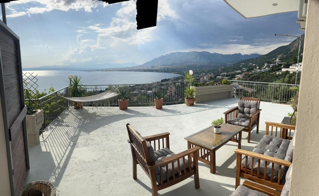 a balcony with chairs and a table and a view of the water at Messinian Sun in Kalamata