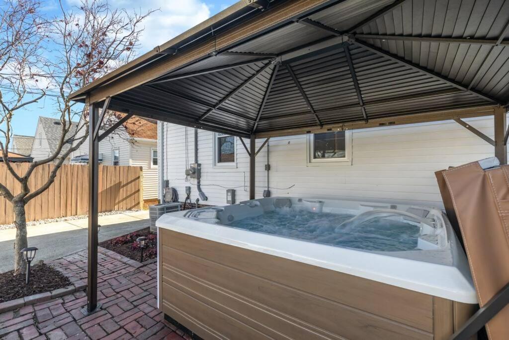 a hot tub under an umbrella in a backyard at Parma Home w/ Hot Tub and Arcade room! in Parma