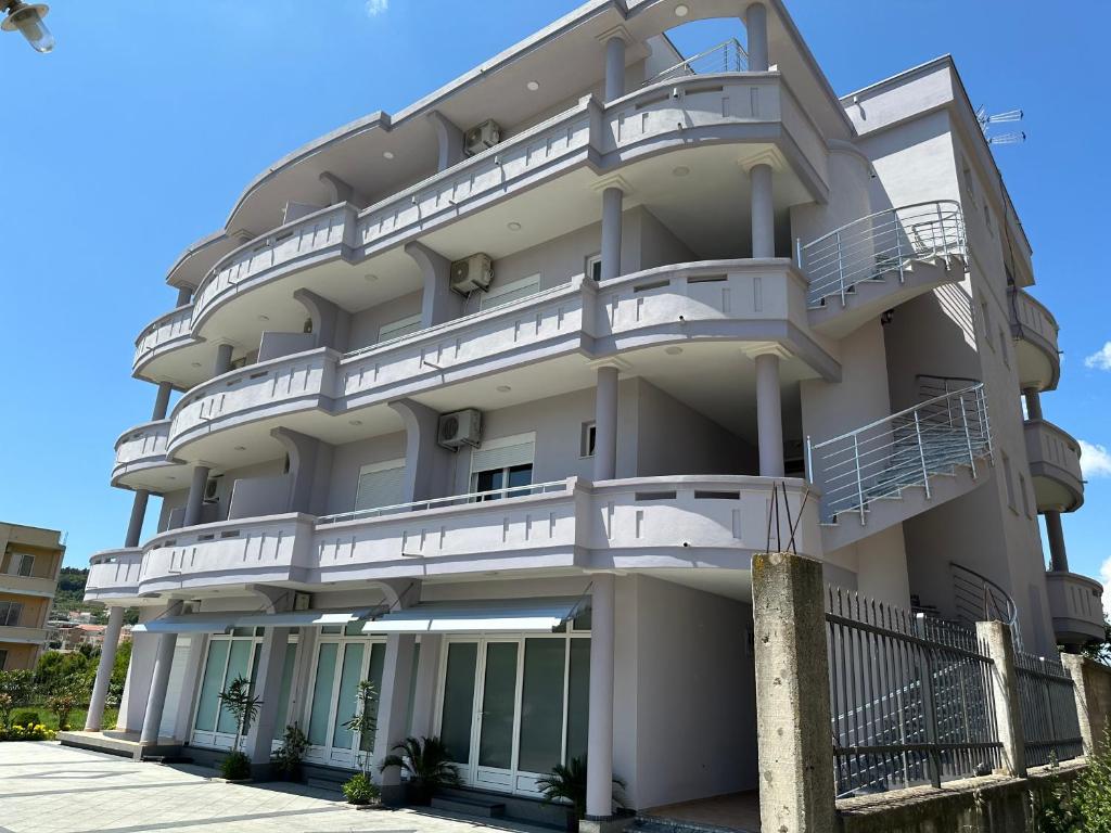 un gran edificio blanco con balcones. en Apartments Flamida en Ulcinj