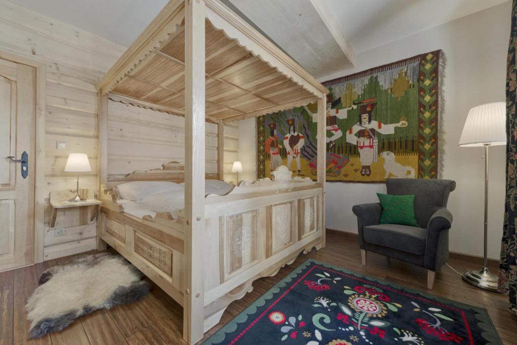 sypialnia z łóżkiem z baldachimem i krzesłem w obiekcie Willa Tatiana Lux w Zakopanem