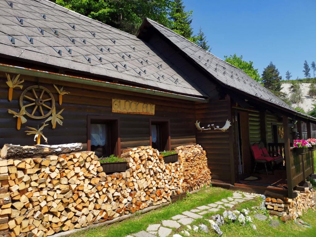 una baita di tronchi con un mucchio di legna da ardere di Waldhütte Glück Auf a Nötsch bei Bleiberg