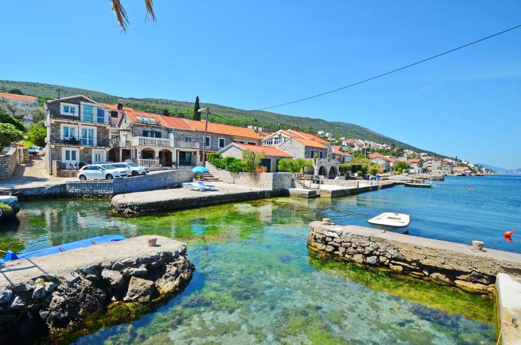 a river with houses and boats in the water at Apartment Romana in Tivat