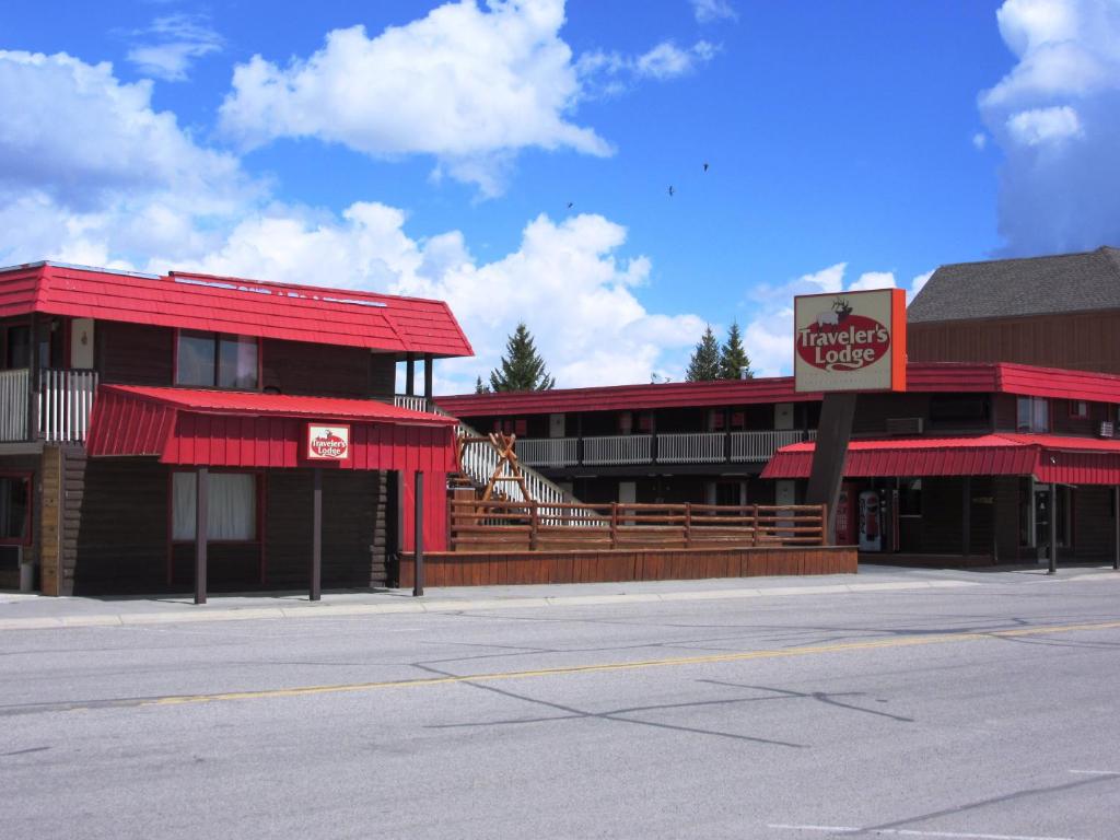 a red building with a sign on the side of a street at Travelers Lodge in West Yellowstone