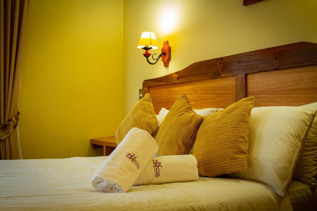 a bedroom with a bed with pillows on it at Hotel Departamentos del Sur in Puerto Montt