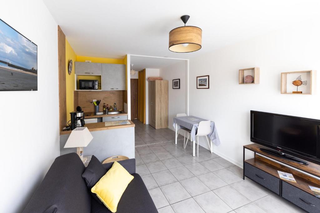 un salon avec un canapé et une télévision à écran plat dans l'établissement ~Joli studio à 100 m de la plage, à Les Sables-dʼOlonne