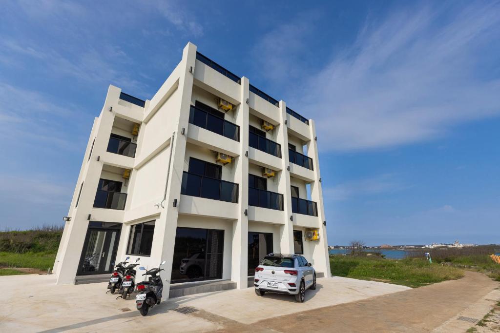 a white building with motorcycles parked in front of it at Yonezawa Guest House in Magong