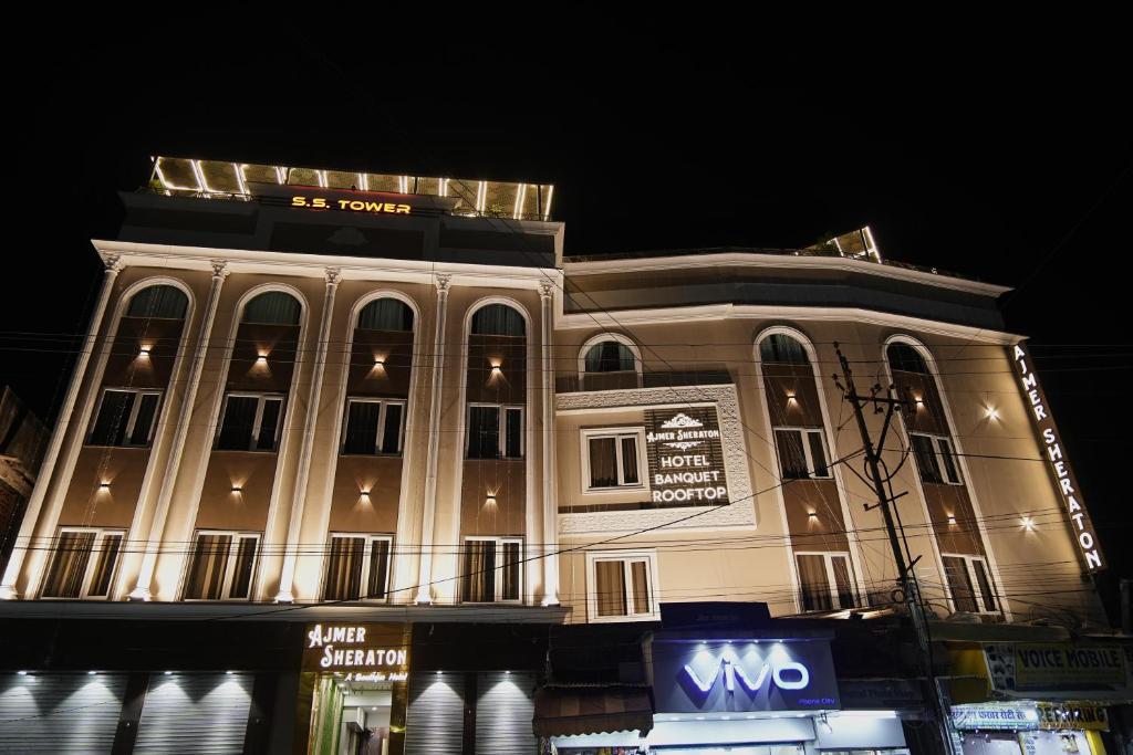 un grande edificio con un cartello di fronte di HOTEL AJMER SHERATON a Ajmer