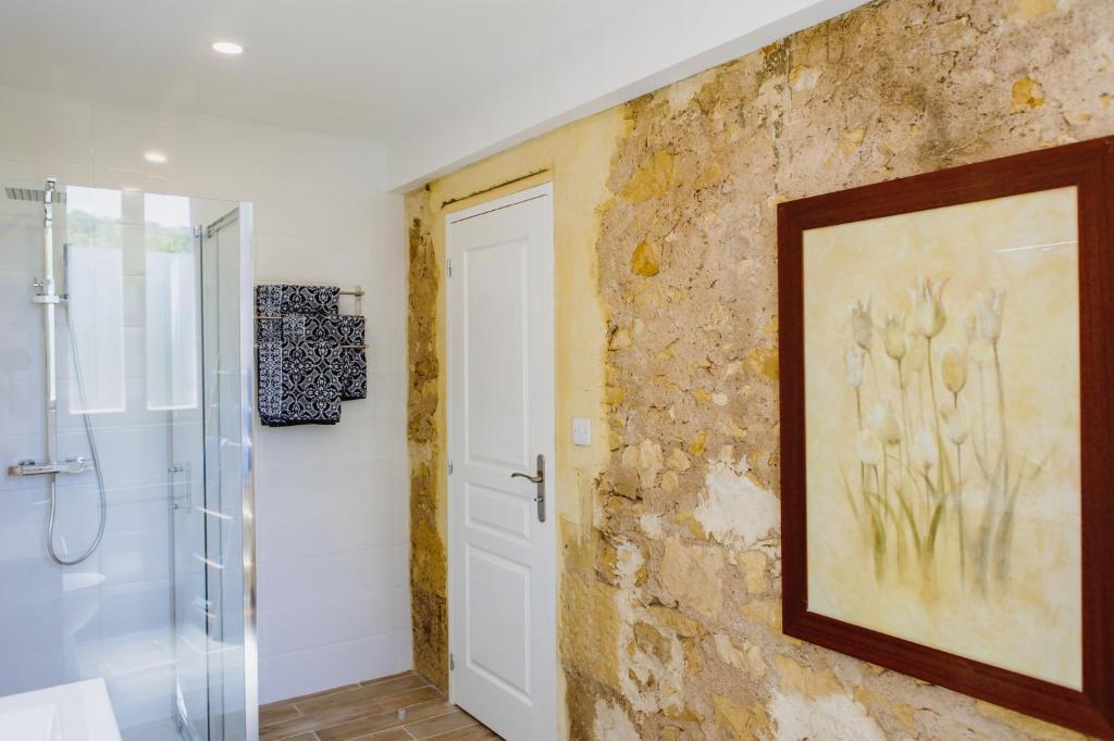 een badkamer met een douche en een schilderij aan de muur bij River House in Lalinde