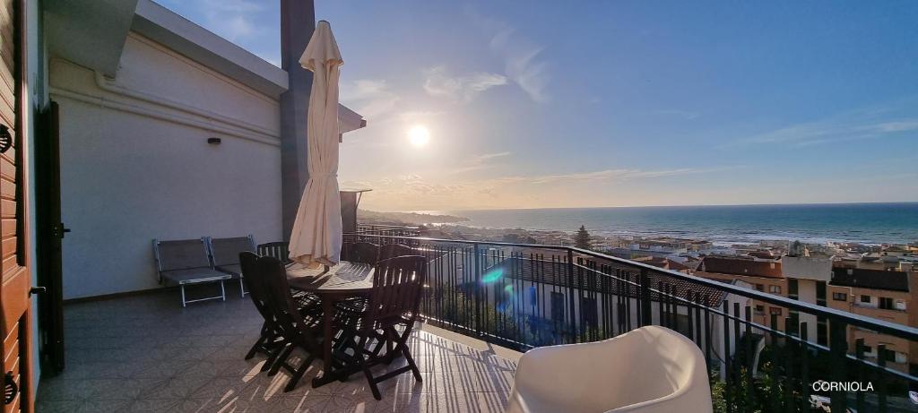 balcón con mesa, sillas y vistas al océano en Villa Vittoria, en Cefalú