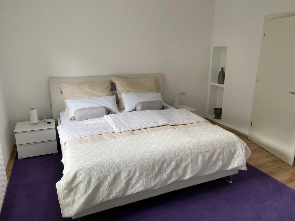 een slaapkamer met een groot bed met witte lakens bij Appartement Seehof in Nassereith