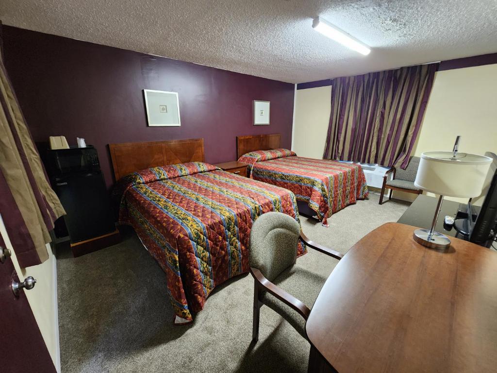 een hotelkamer met 2 bedden en een tafel bij Starlite Motor Inn in Absecon