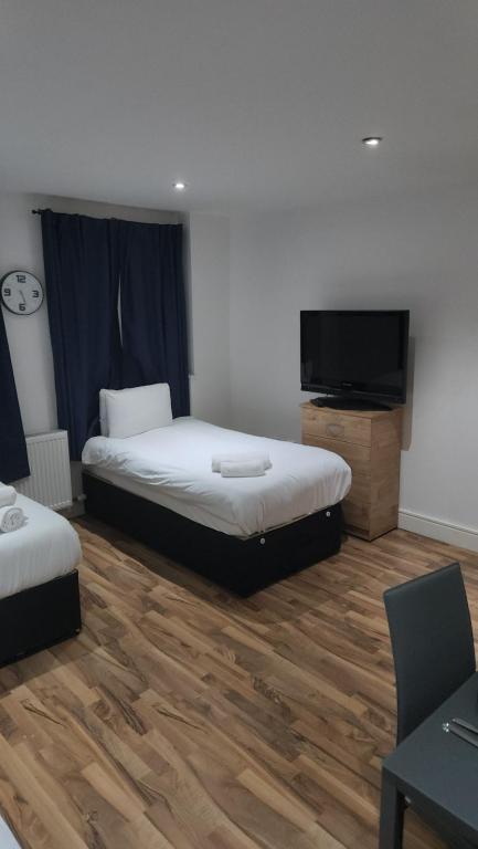 a room with two beds and a flat screen tv at City Sparrow Apartment 3 in London