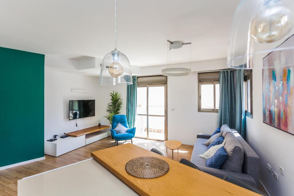 ein Wohnzimmer mit einem Sofa und einem Tisch in der Unterkunft One Step from the Sea. Apartment 5 +parking. in Tel Aviv