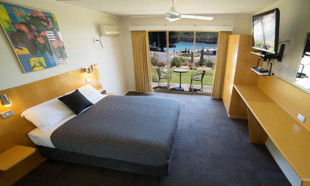 a hotel room with a bed and a television at Loch Ard Motor Inn in Port Campbell
