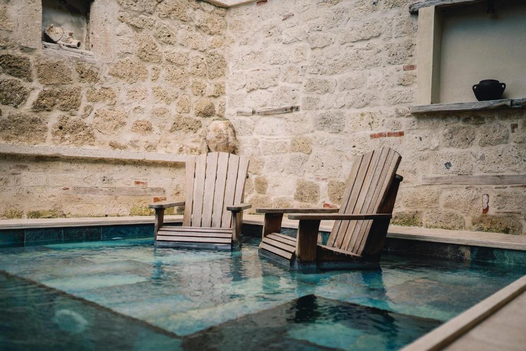 two chairs and a table in a swimming pool at Suare Alaçatı in Alacati