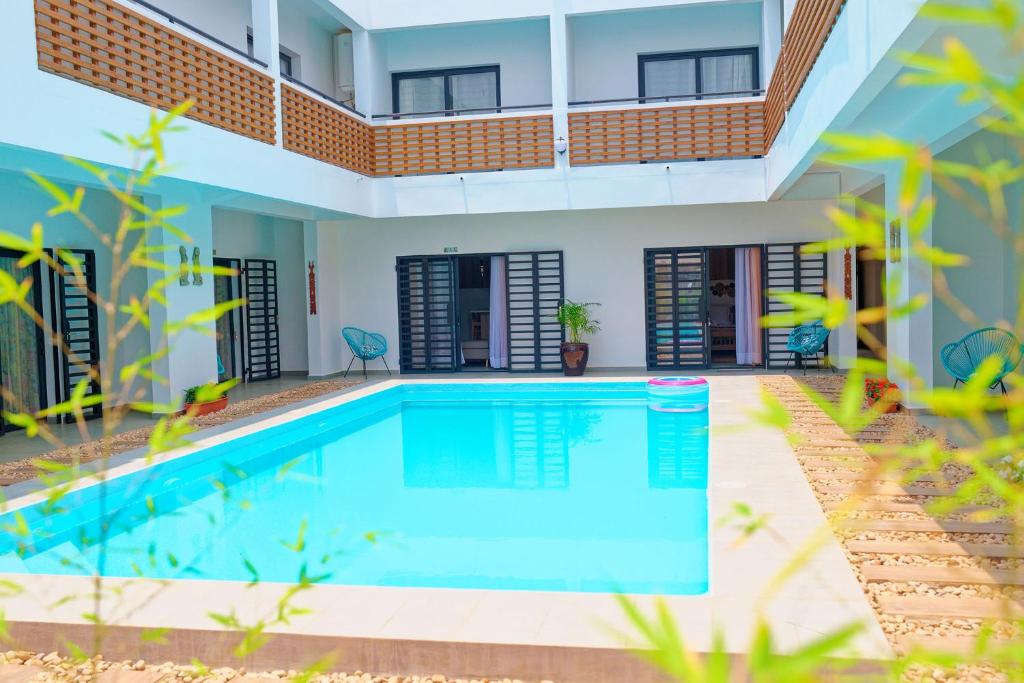 a swimming pool in front of a house at Ofim Holidays in Ambohidratrimo
